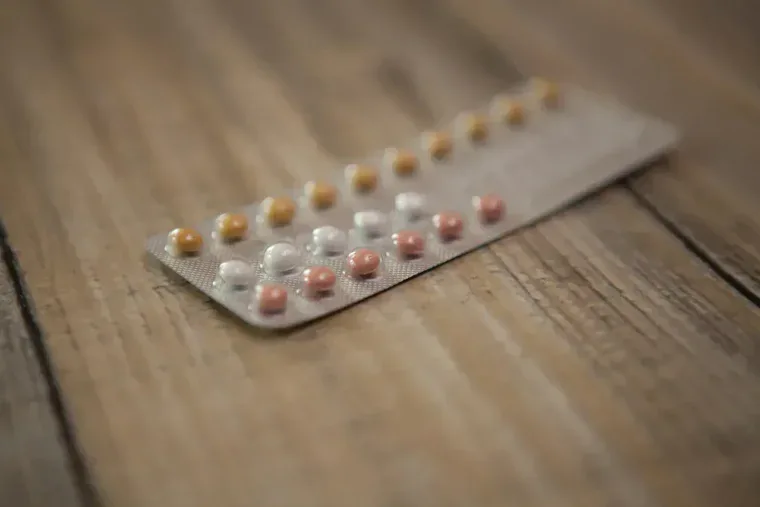 Blister tabletek antykoncepcyjnych na drewnianym blacie